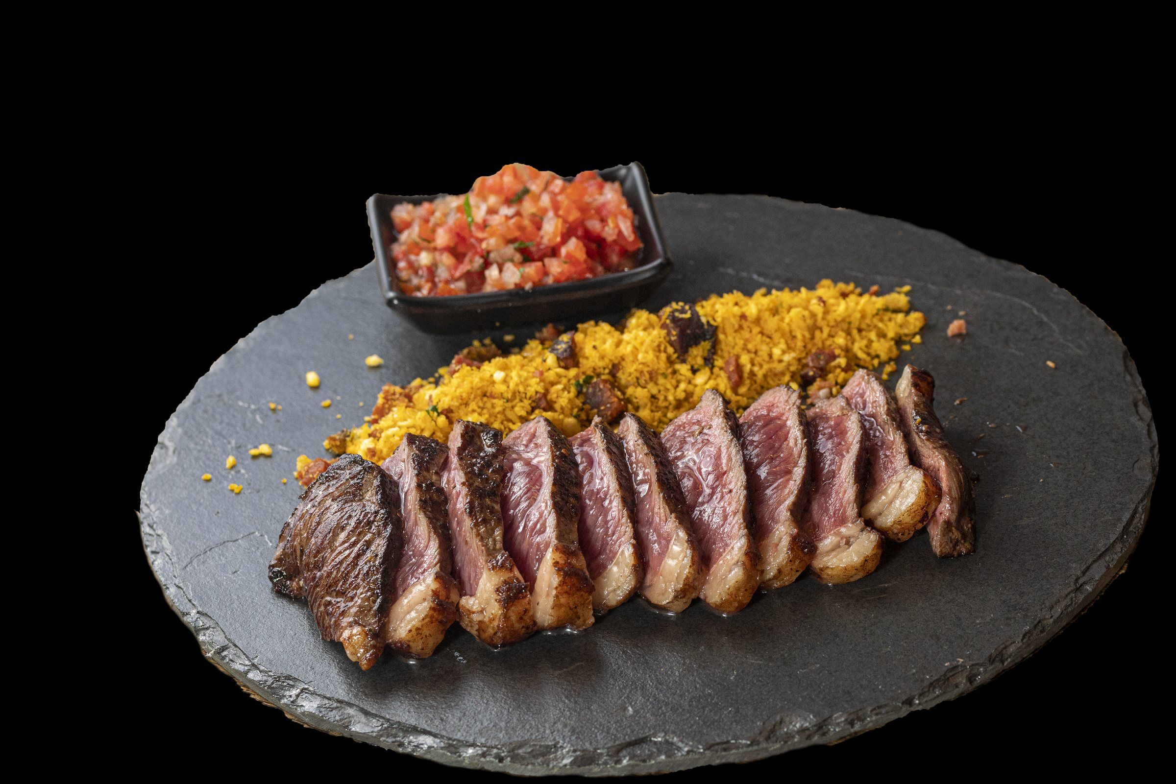 Picanha fatiada na pedra de ardósia com farofa cítrica e vinagrete
